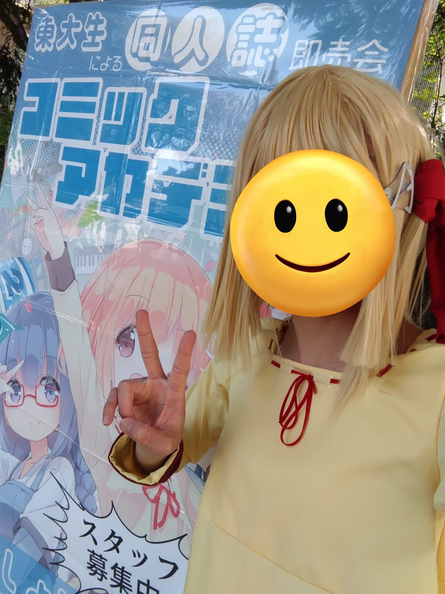 立て看板の前でポーズをとるカコちゃん